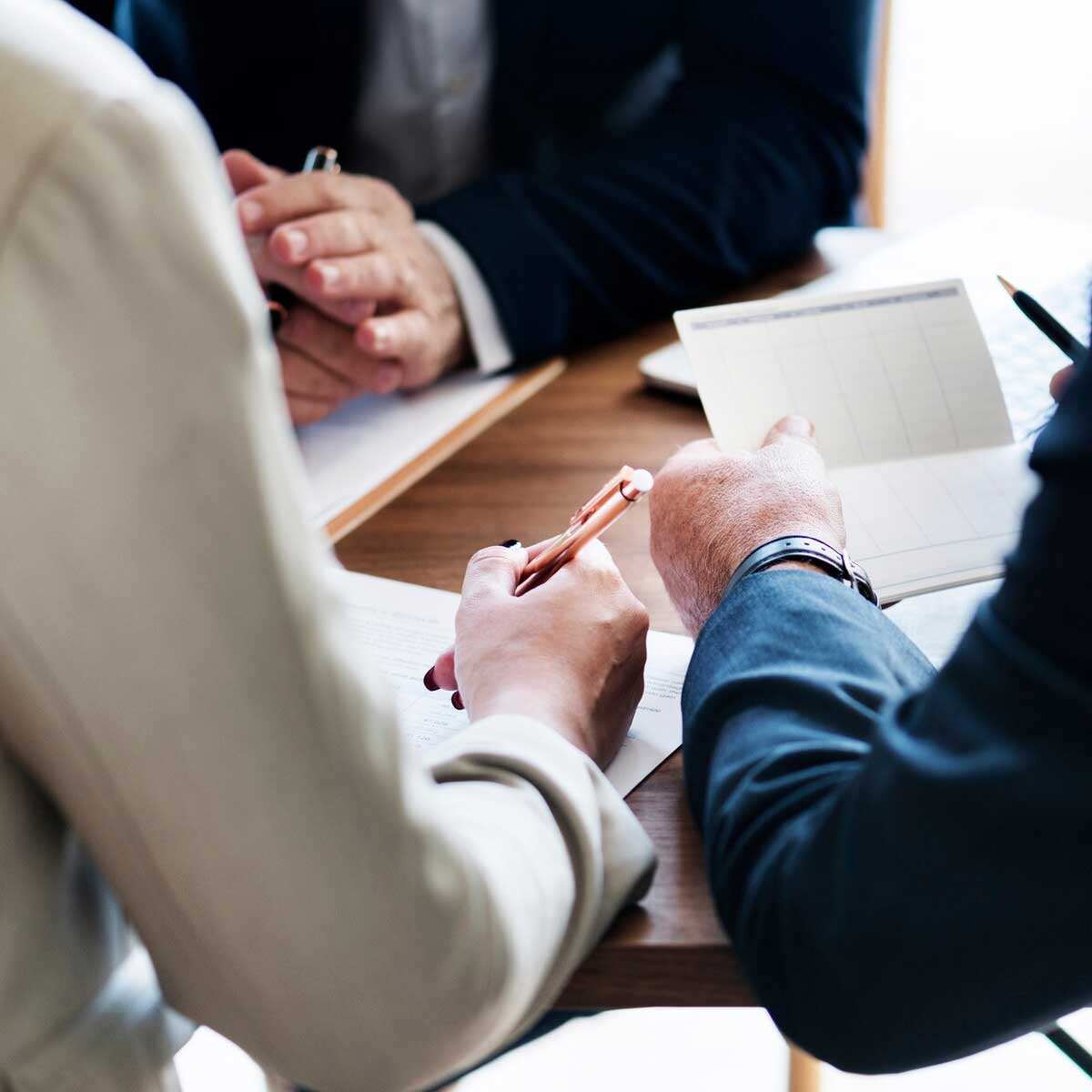 people buying a business meet with their lawyer to discuss finer details of the contract